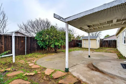 a patio with a table and chairs and potted plants