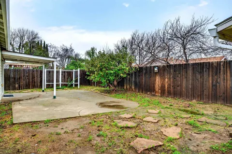 a backyard of a house with table and chairs