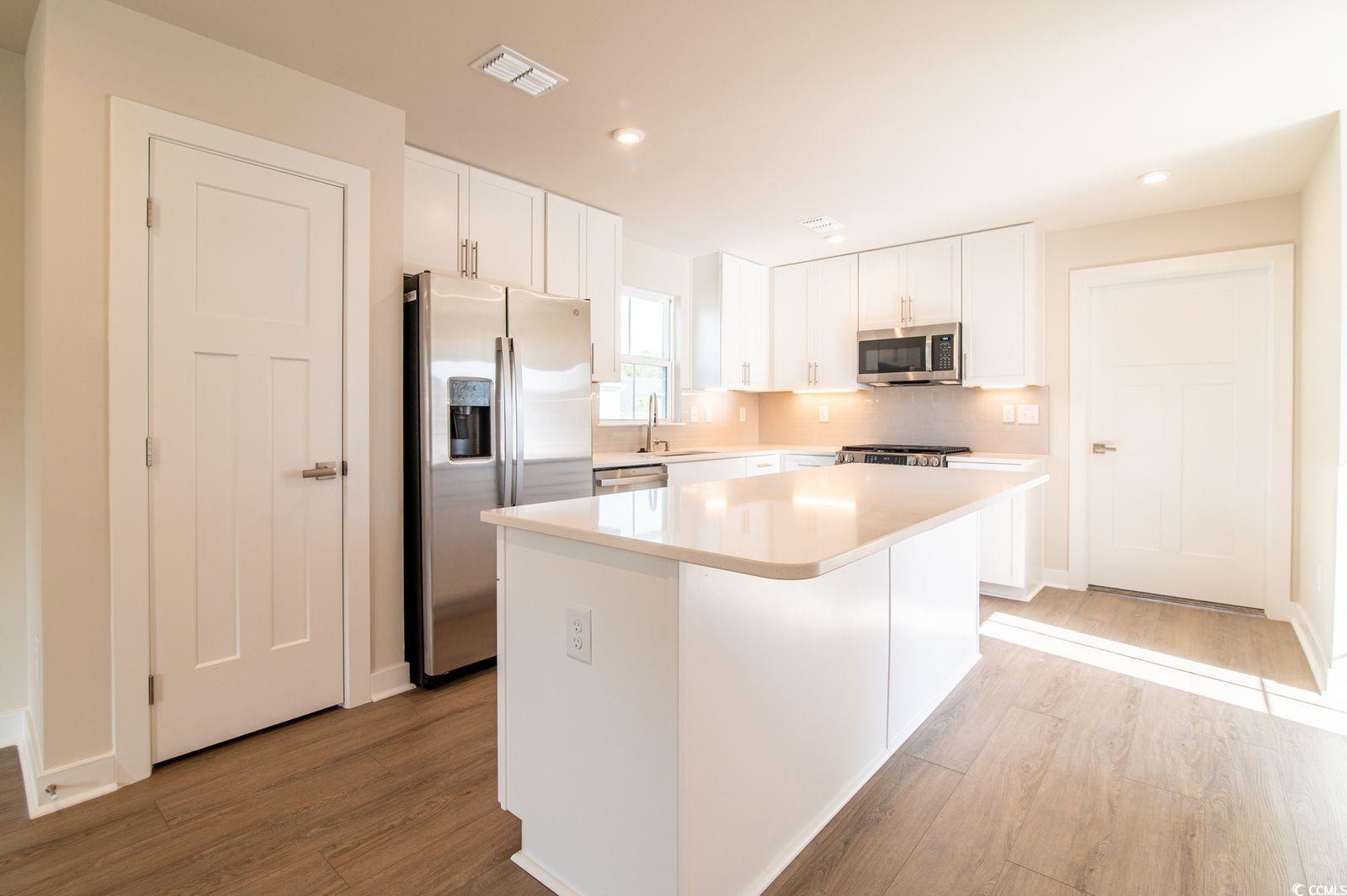 2812 Rowyn Street Longs, SC 29568 - Photo 4 of 27 Kitchen with white cabinets, stainless steel appliances, a center island, light wood-style flooring, and recessed lighting