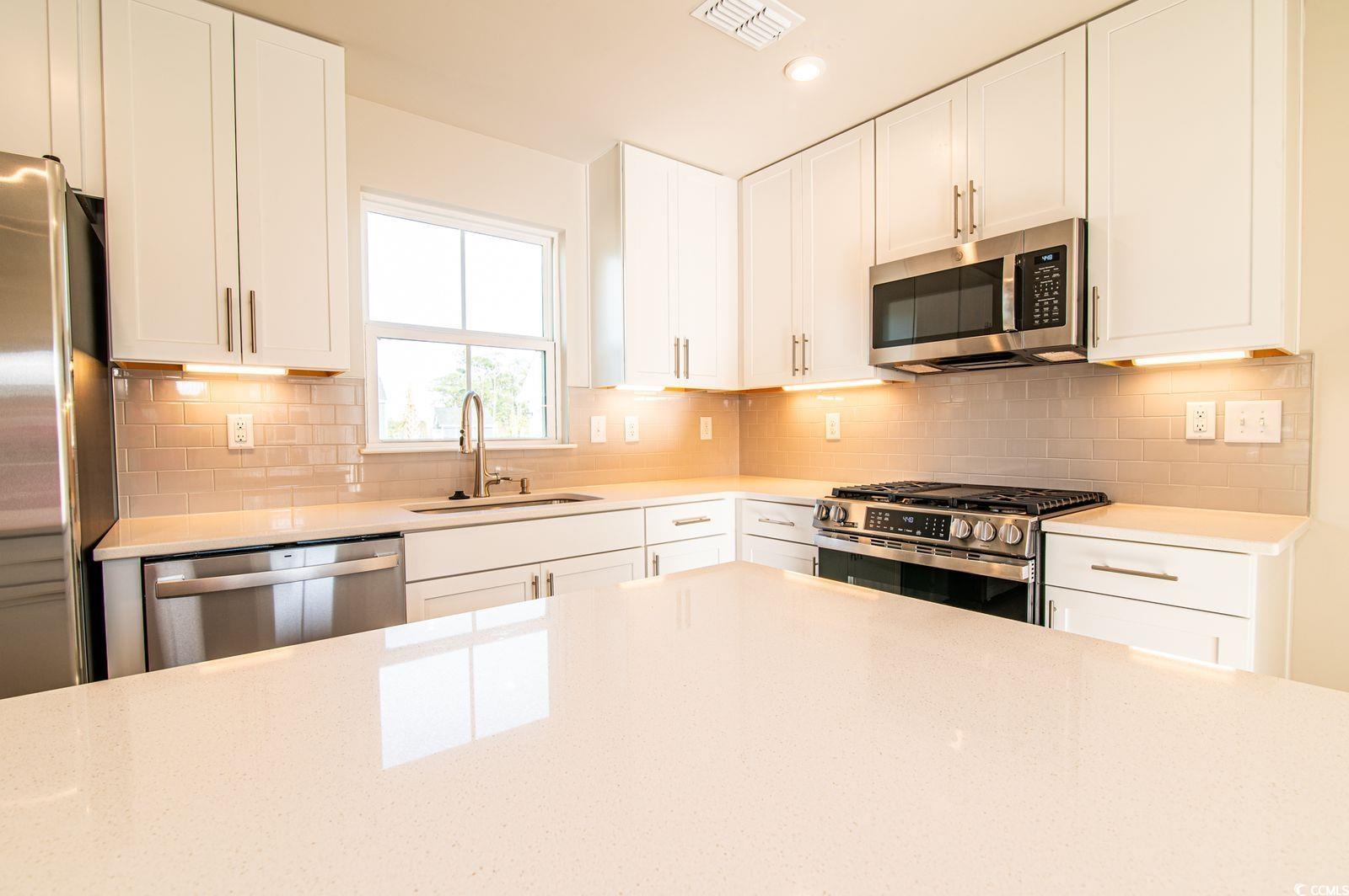 2812 Rowyn Street Longs, SC 29568 - Photo 5 of 27 Kitchen with stainless steel appliances, white cabinets, light stone counters, tasteful backsplash, and recessed lighting