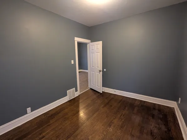 an empty room with wooden floor and closet