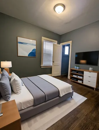 a bedroom with a bed and a flat screen tv