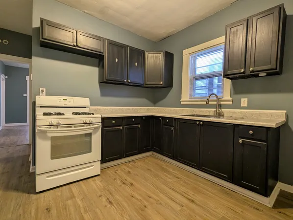 a kitchen with a sink stove and cabinets