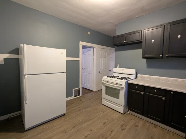 a kitchen with a refrigerator sink stove and cabinets
