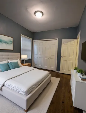 a bedroom with a large bed and a flat tv screen on dresser