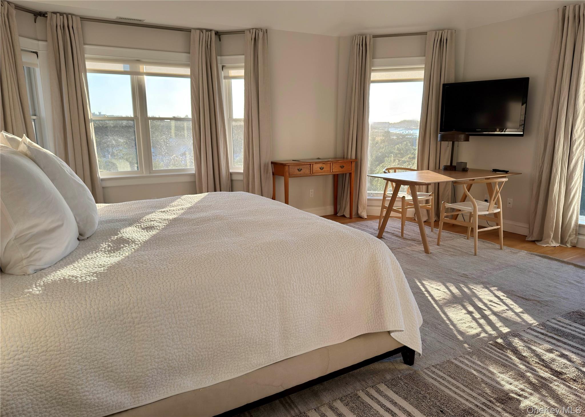 162 Dune Road Quogue, NY 11959 - Photo 12 of 28 a spacious bedroom with a bed and a flat screen tv