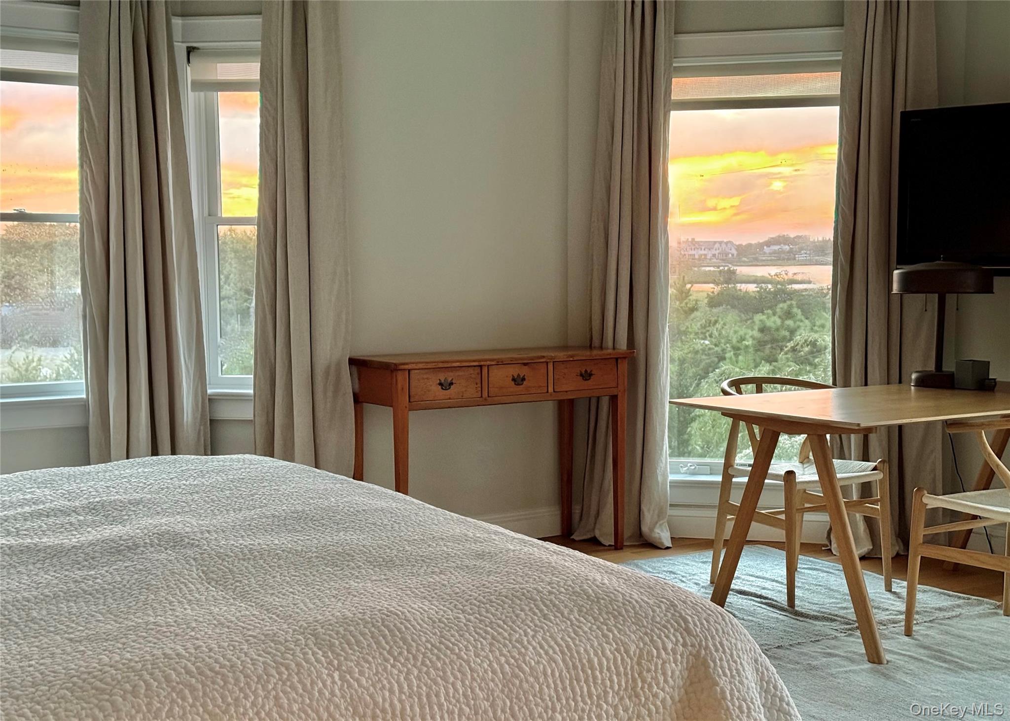 162 Dune Road Quogue, NY 11959 - Photo 13 of 28 a bedroom with a bed and a flat tv screen next to a window