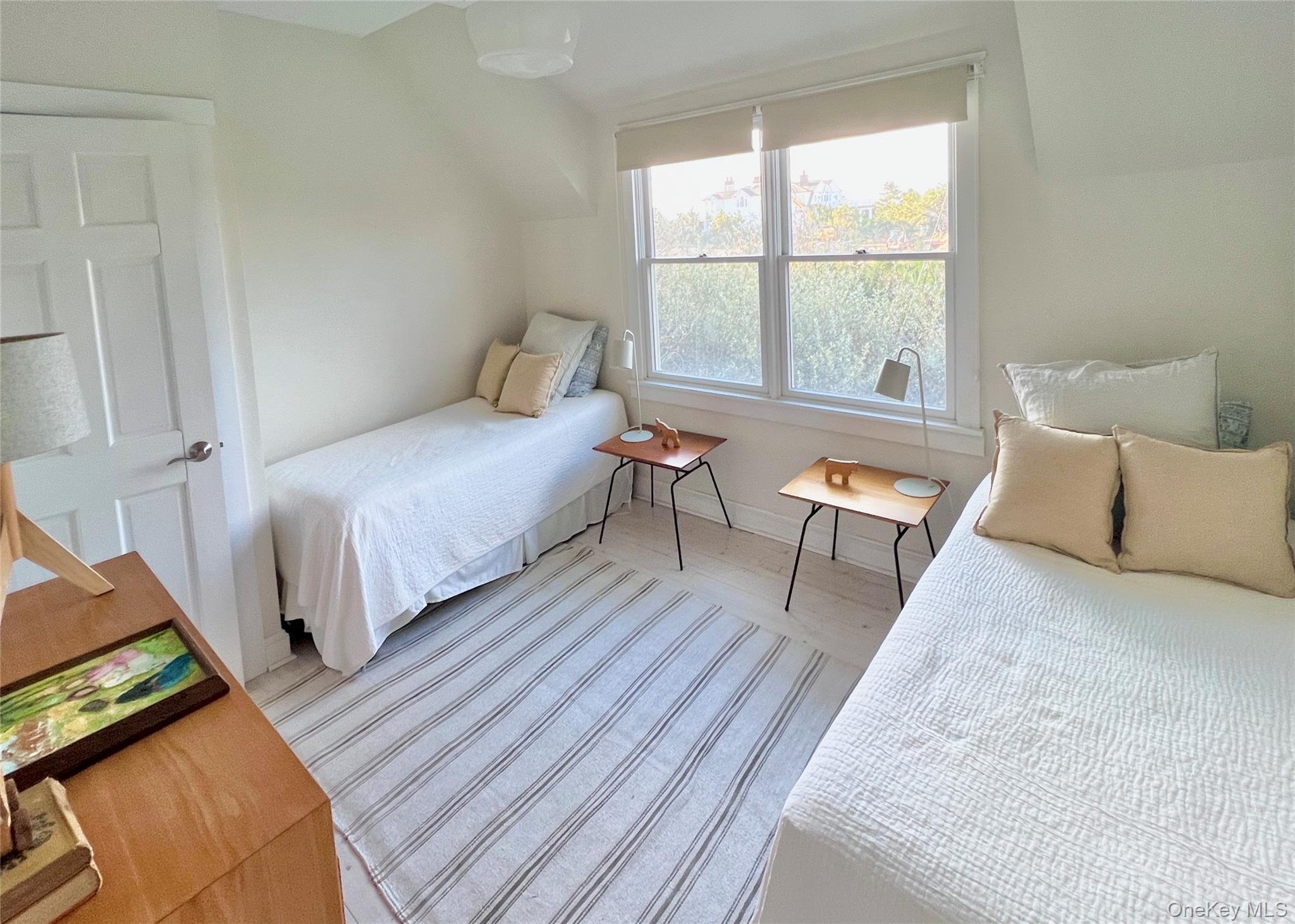 162 Dune Road Quogue, NY 11959 - Photo 16 of 28 a bedroom with a bed and wooden floor