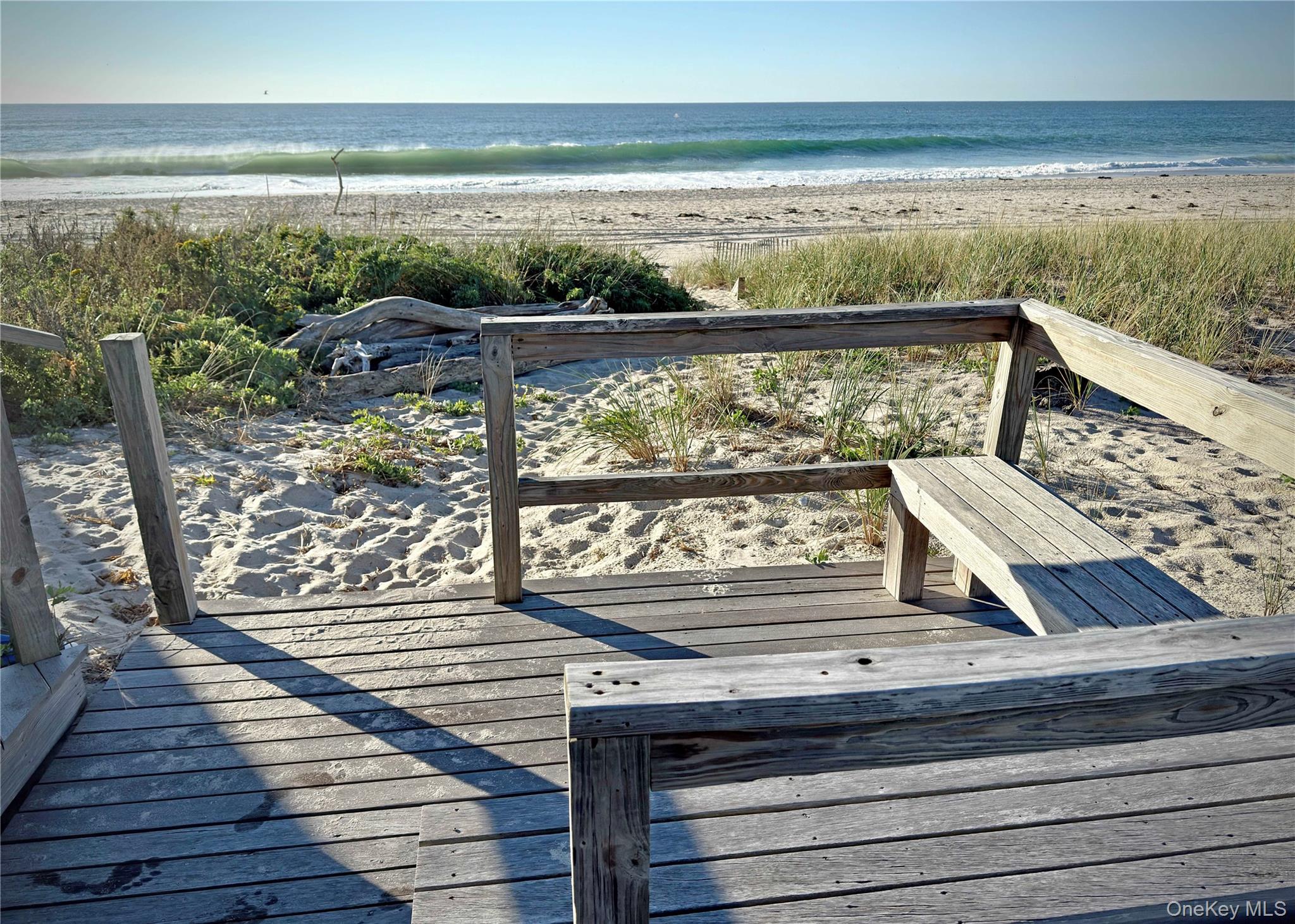162 Dune Road Quogue, NY 11959 - Photo 19 of 28 a view of a balcony with wooden floor and outdoor space