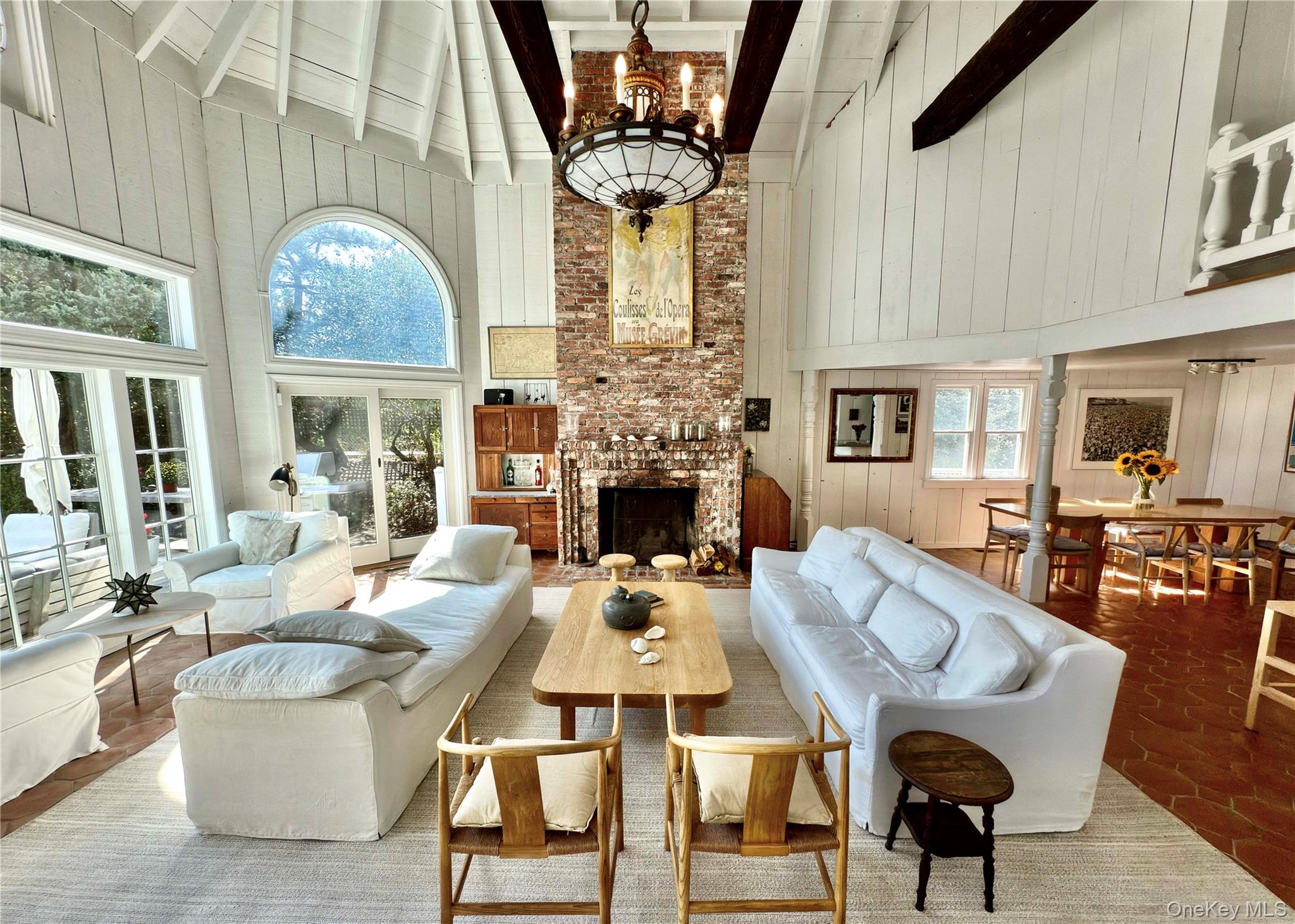 162 Dune Road Quogue, NY 11959 - Photo 5 of 28 a living room with fireplace furniture and a chandelier