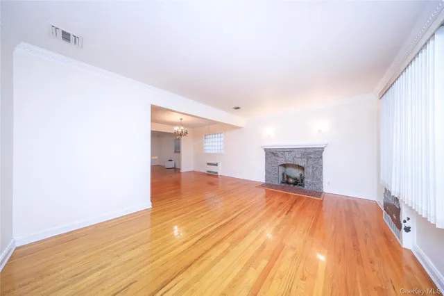 a view of empty room with wooden floor and fireplace