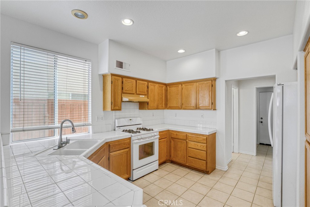 19321 Ackerman Avenue Newhall, CA 91321 - Photo 9 of 20 a kitchen that has a sink a stove and a microwave