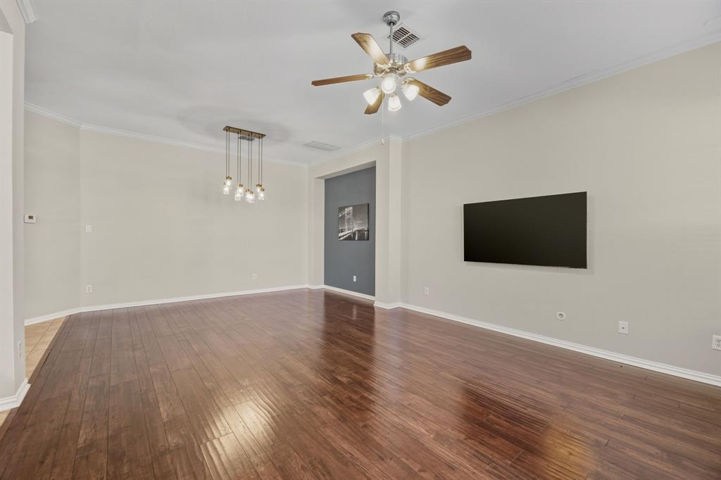 4027 Rome Court Irving, TX 75038 - Photo 10 of 33 a view of an empty room with wooden floor and a ceiling fan