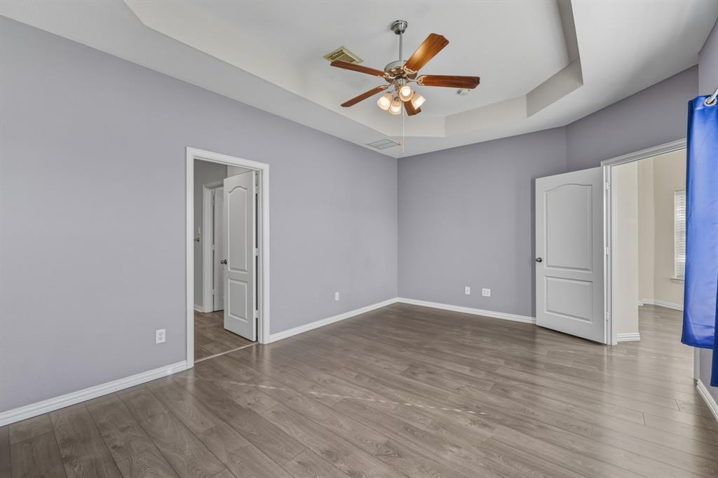 4027 Rome Court Irving, TX 75038 - Photo 18 of 33 an empty room with wooden floor and ceiling fan