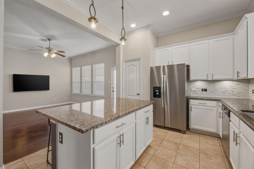4027 Rome Court Irving, TX 75038 - Photo 9 of 33 a kitchen with kitchen island granite countertop a sink a refrigerator and a stove top oven