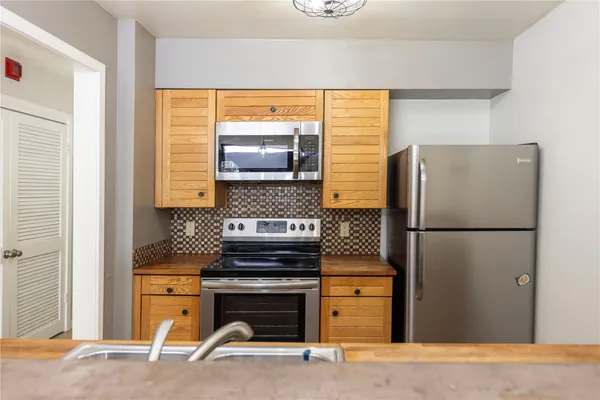 a kitchen with stainless steel appliances a refrigerator and a stove top oven