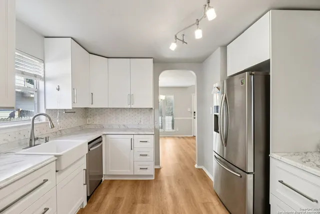 a kitchen with a refrigerator sink and cabinets