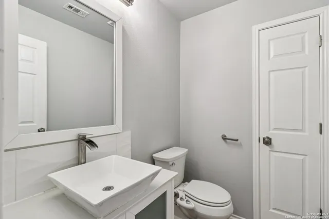 a bathroom with a sink a toilet and a mirror