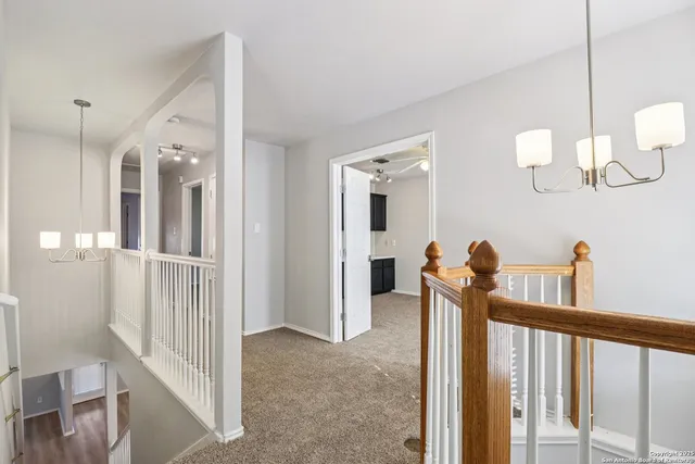 a view of a hallway with dining room and chandelier