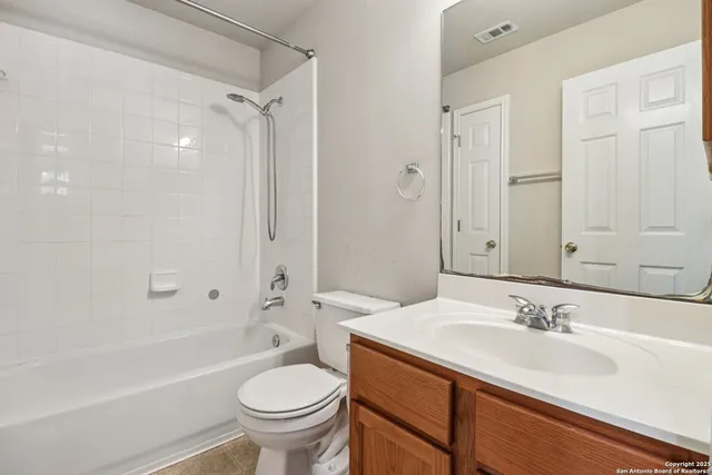 a bathroom with a granite countertop sink a toilet and shower