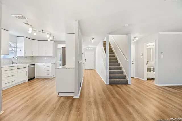 a view of a kitchen with wooden floor and electronic appliances