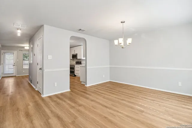 a view of a kitchen with wooden floor and a ceiling fan