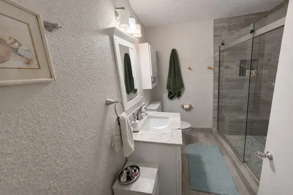 a bathroom with a sink and mirror with bathtub