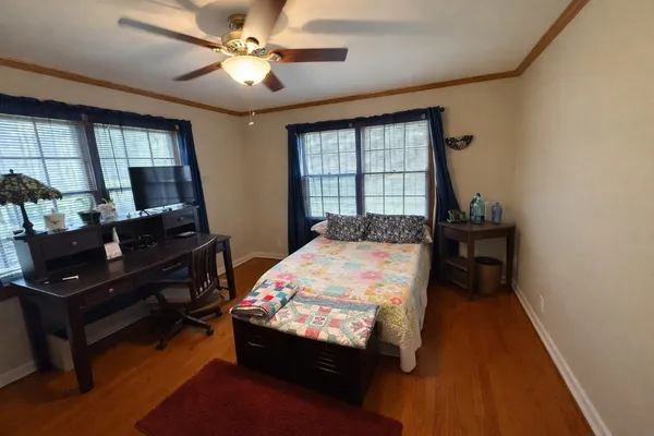 a bedroom with a bed and wooden floor