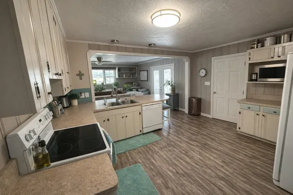 a kitchen with stainless steel appliances a sink a stove a refrigerator and cabinets