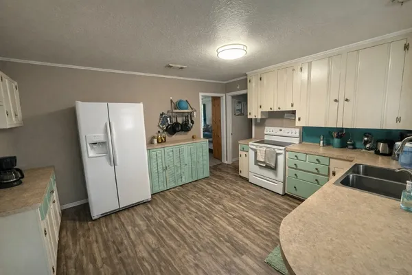 a kitchen with stainless steel appliances a refrigerator a sink a stove top oven and cabinets