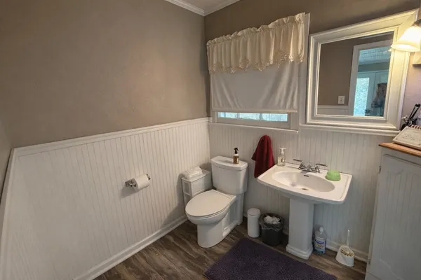 a bathroom with a toilet sink and mirror