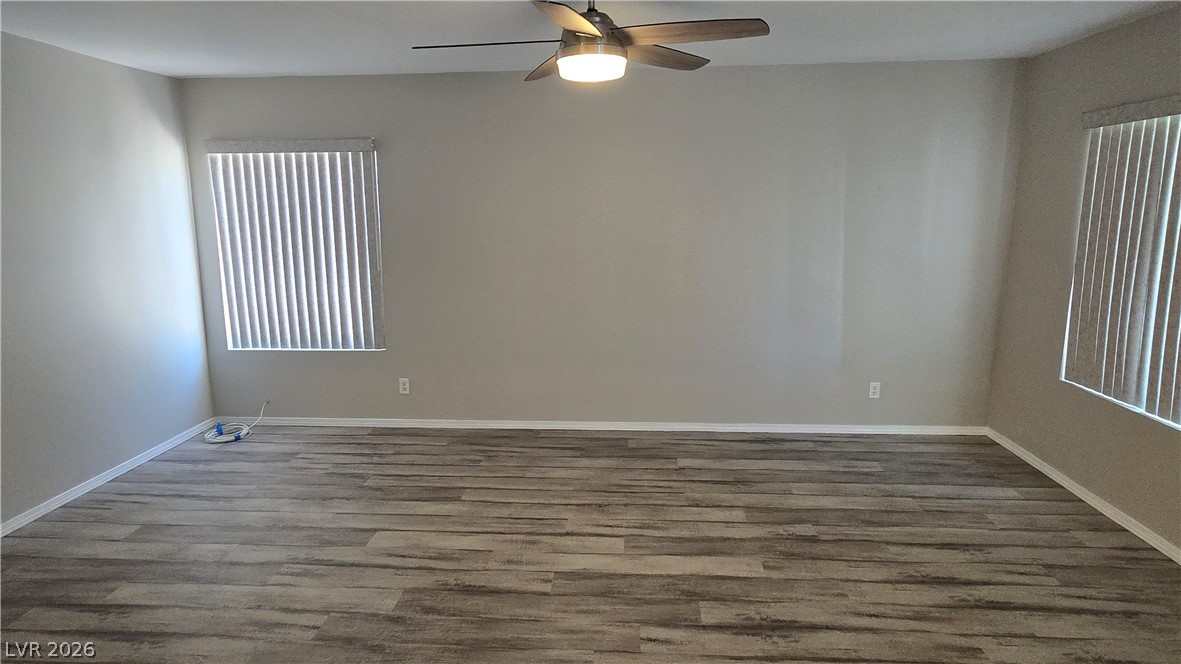 3849 Reflection Way Las Vegas, NV 89147 - Photo 4 of 25 An empty, freshly painted room with wood flooring, offering a neutral canvas.
