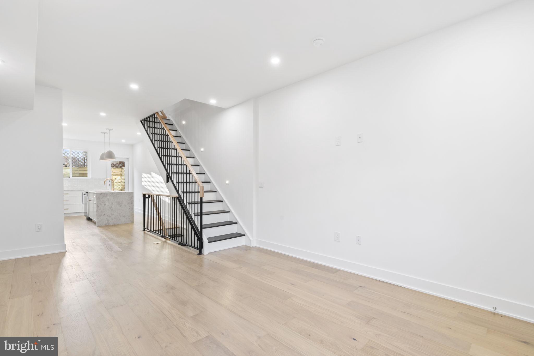 1318 South 8th Street Philadelphia, PA 19147 - Photo 15 of 47 a view of an empty room with wooden floor stairs and a window