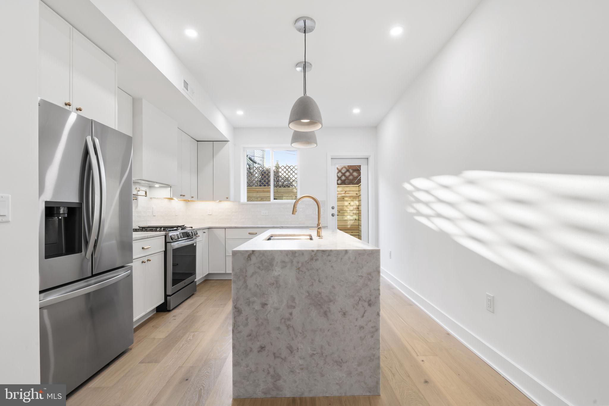 1318 South 8th Street Philadelphia, PA 19147 - Photo 9 of 47 a large kitchen with kitchen island a large counter top space stainless steel appliances and cabinets