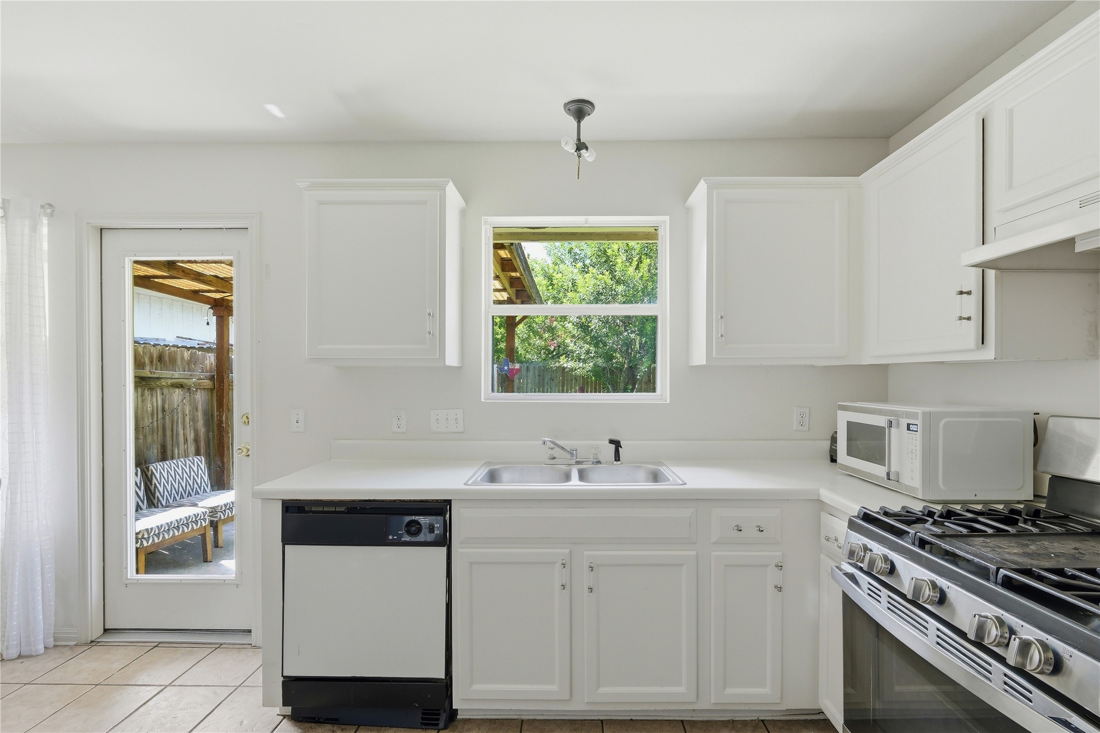 310 Raintree Drive Georgetown, TX 78626 - Photo 7 of 12 A well-equipped kitchen provides essential appliances and a pleasant view to the backyard.