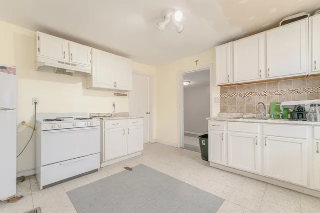 a kitchen with white cabinets and white appliances