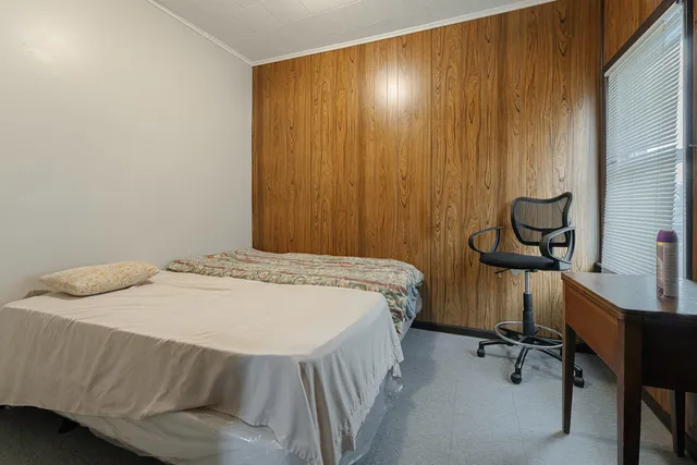 a bedroom with a bed and a chair