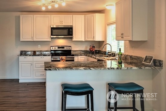 139 West Frostad Road Oak Harbor, WA 98277 - Photo 3 of 39 a kitchen with stainless steel appliances granite countertop a stove a sink and a microwave