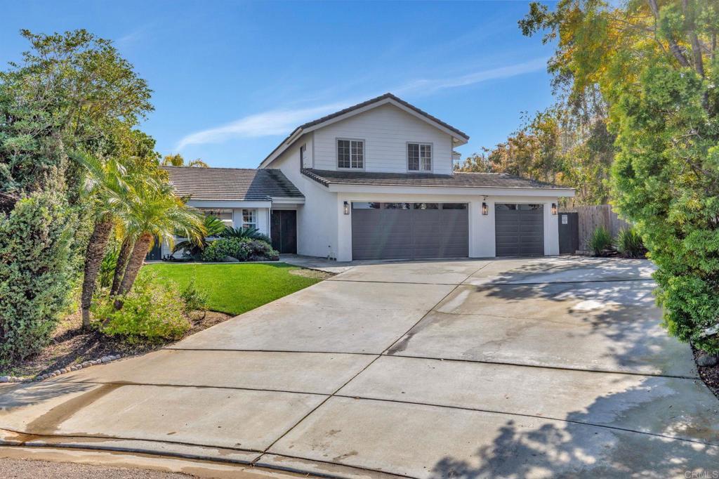 a front view of a house with a yard and trees