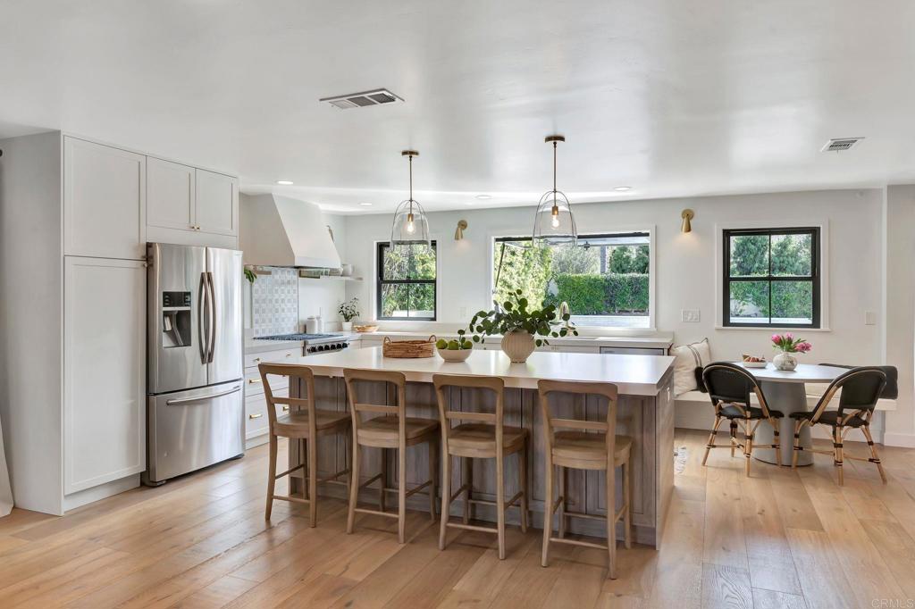 201 Sierra Ridge Drive Encinitas, CA 92024 - Photo 2 of 45 a kitchen with stainless steel appliances a dining table chairs stove and refrigerator