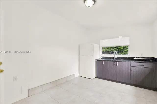 a view of kitchen with window and cabinets