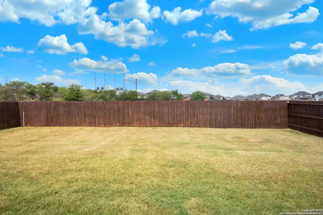 a view of a swimming pool with an outdoor space and wooden fence