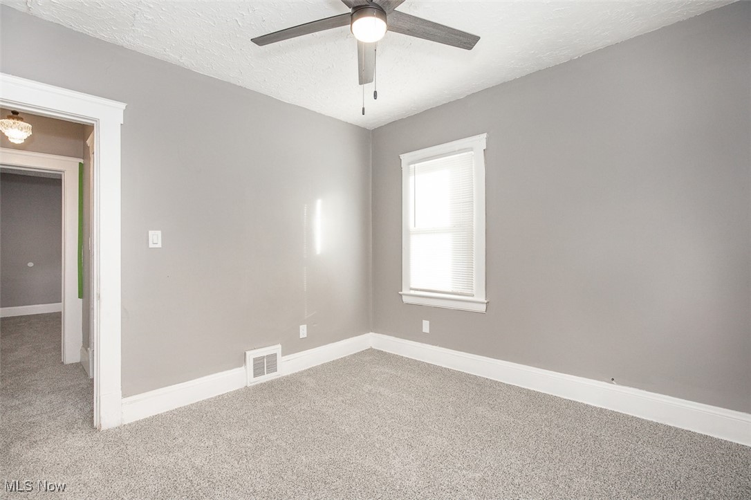 1045 Carlyon Road Cleveland, OH 44112 - Photo 16 of 26 Empty room with carpet flooring, a textured ceiling, and ceiling fan