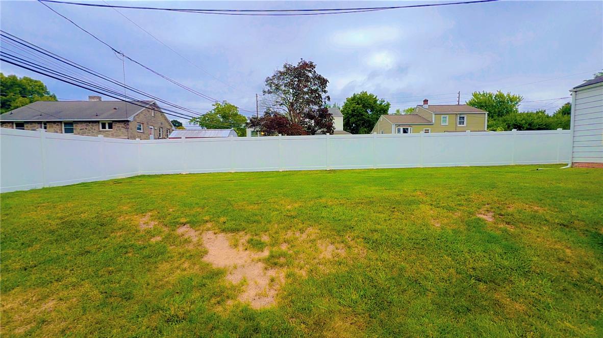 1844 29th Street Southwest Allentown, PA 18103 - Photo 35 of 37 A spacious green lawn is fully enclosed by a clean white vinyl privacy fence.