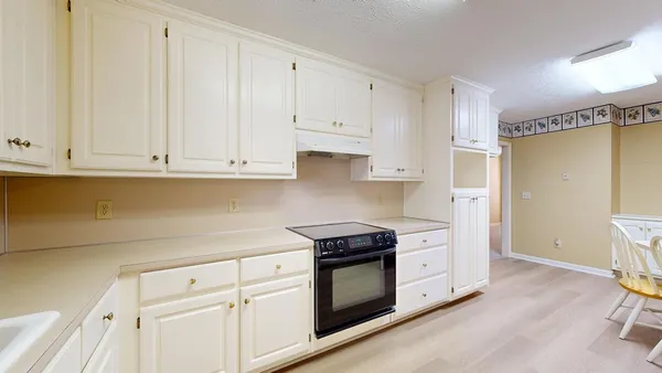 a kitchen with granite countertop white cabinets and white appliances