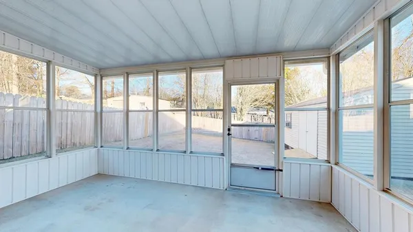 a backyard of a house with a bench and wooden fence