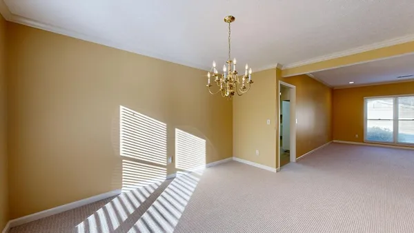 a view of a hallway with chandelier and entryway