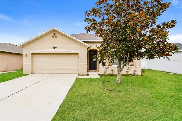 a front view of a house with a yard and trees