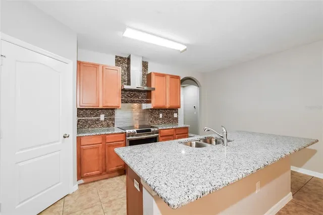 a kitchen with granite countertop a sink a counter top space and cabinets