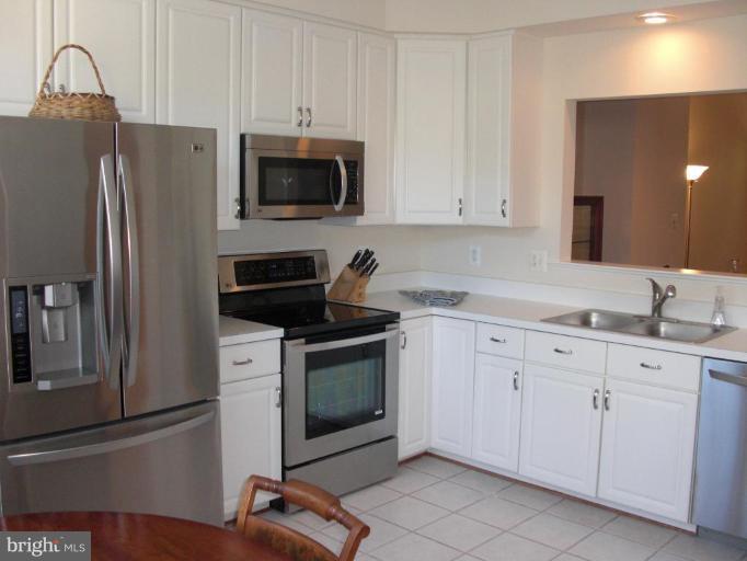 1234 Weatherstone Court Reston, VA 20194 - Photo 3 of 18 a kitchen with stainless steel appliances granite countertop a refrigerator a stove a sink and white cabinets
